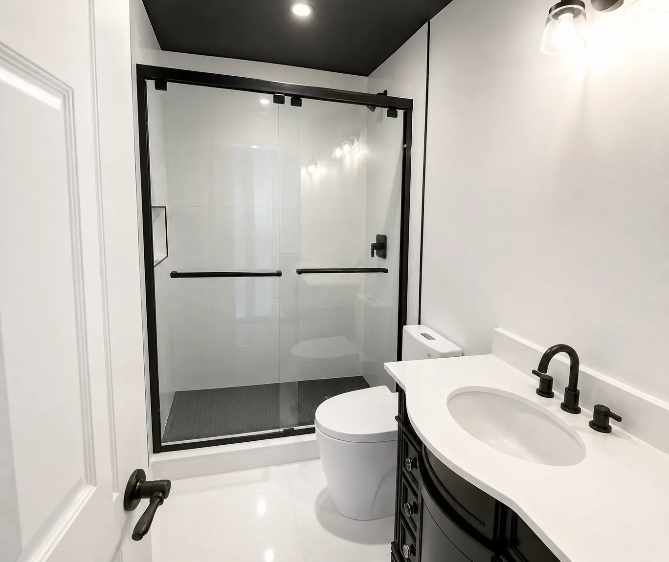 Bathroom remodel converting a dated tiled tub surround into a walk-in shower with black framed glass doors and a black vanity with quartz countertop - After