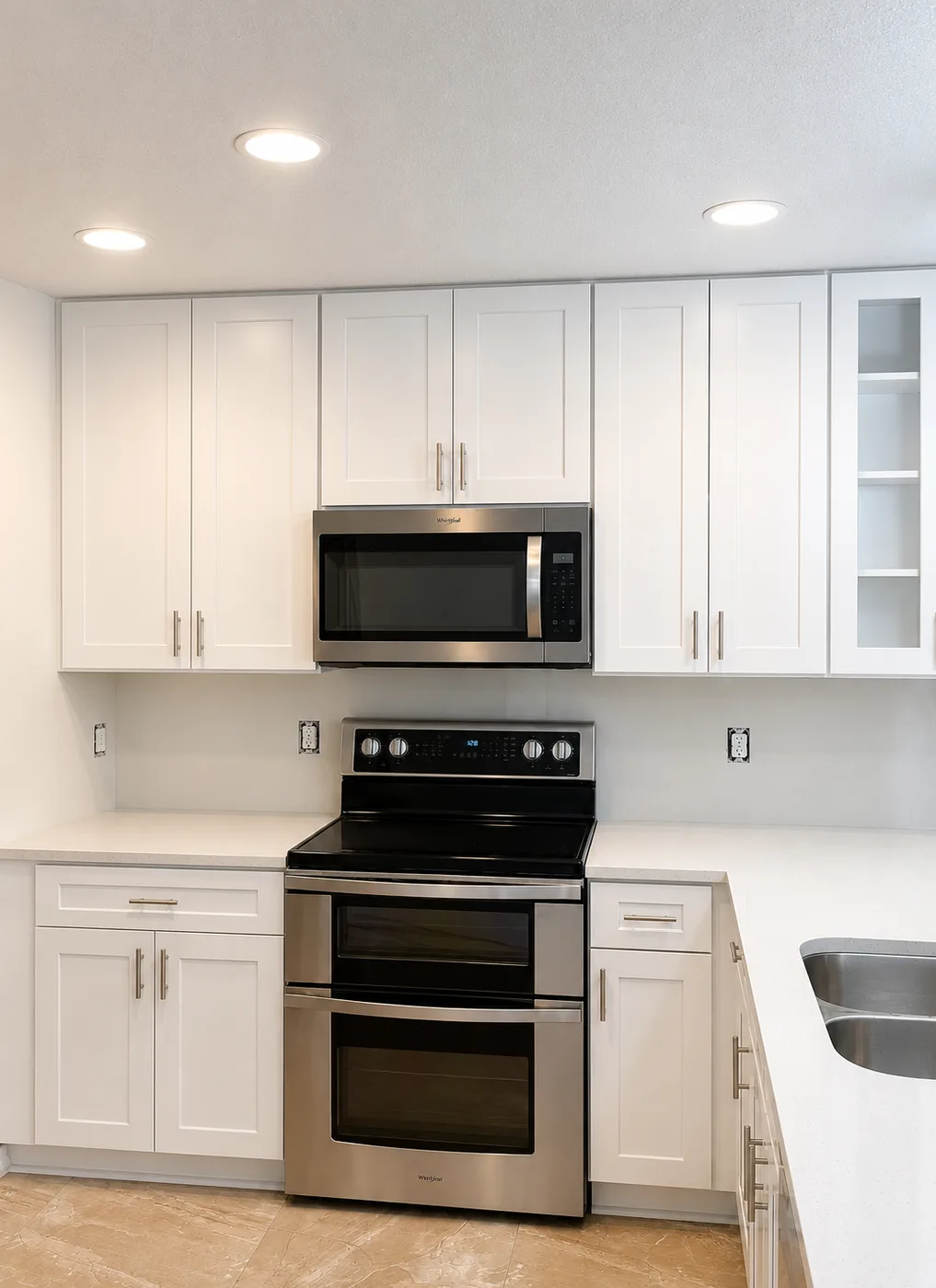 Kitchen remodel replacing dark cherry cabinets with white shaker cabinets, quartz countertops and stainless double oven range - After