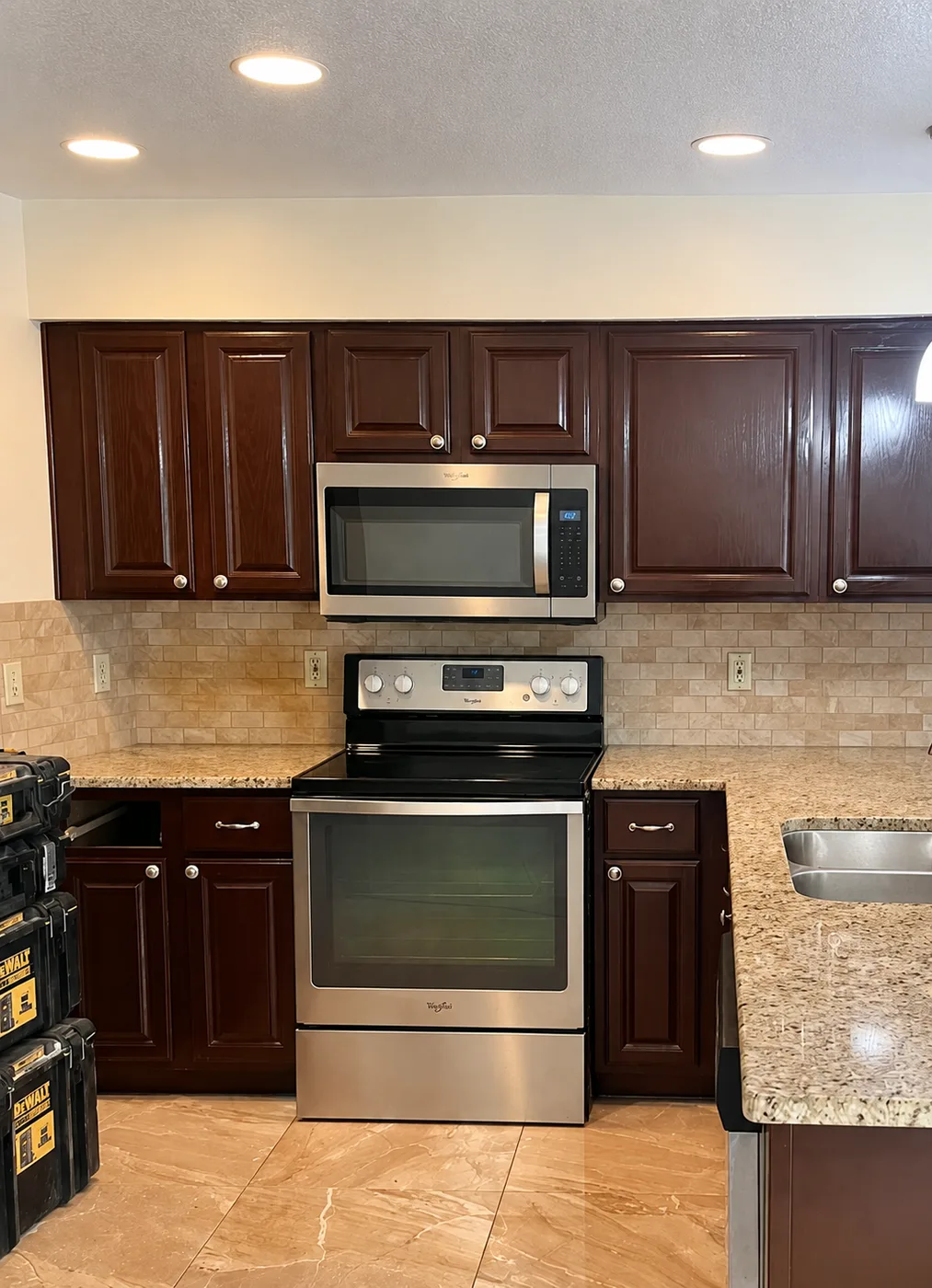 Kitchen remodel replacing dark cherry cabinets with white shaker cabinets, quartz countertops and stainless double oven range - Before