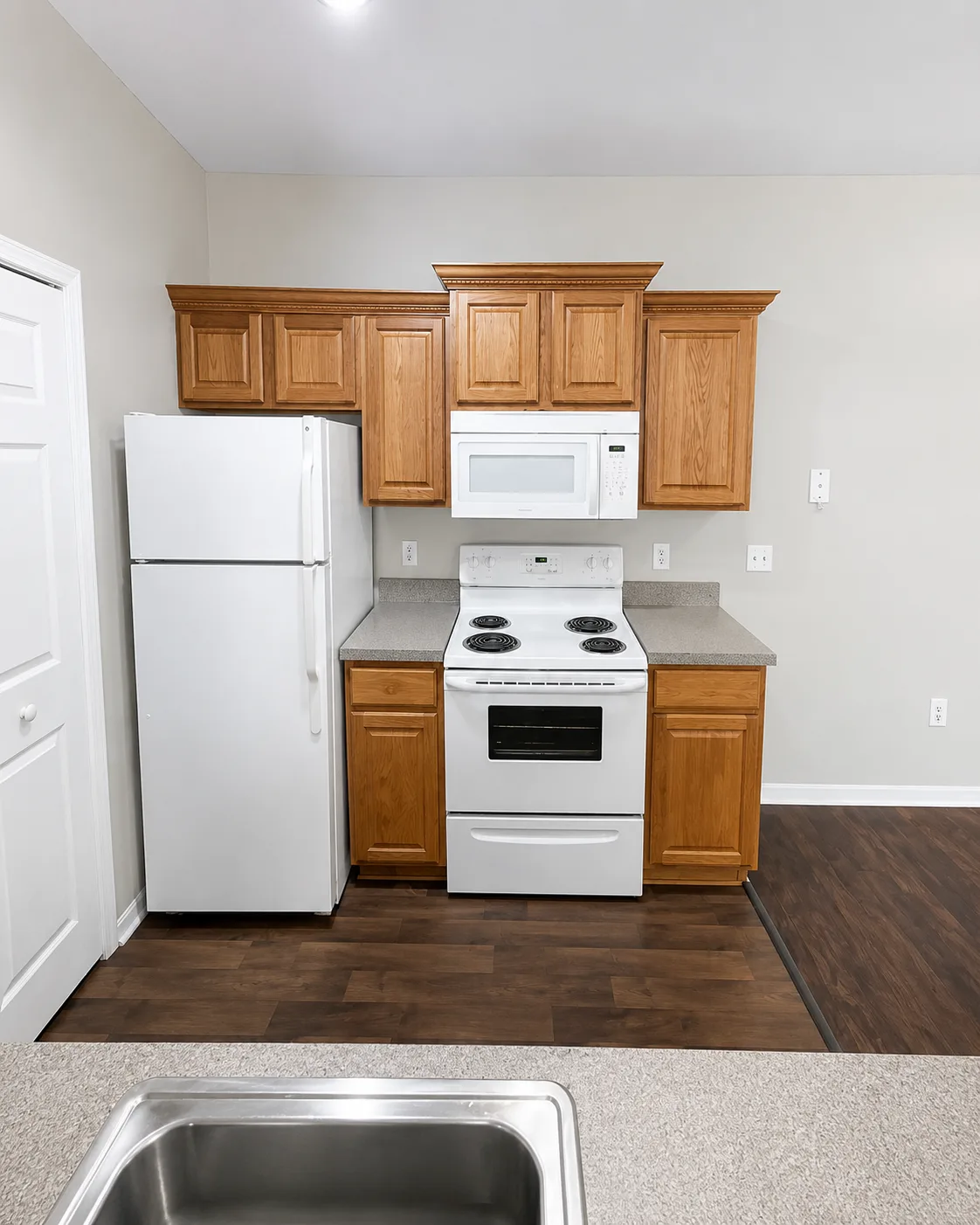 Kitchen remodel replacing honey oak cabinets with two-tone white and black shaker cabinetry, quartz countertops and wood-look vinyl plank flooring - Before